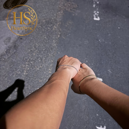 Heartsync permanent bracelet on two wrists. Silver and gold bracelet shows connection. HeartSync.